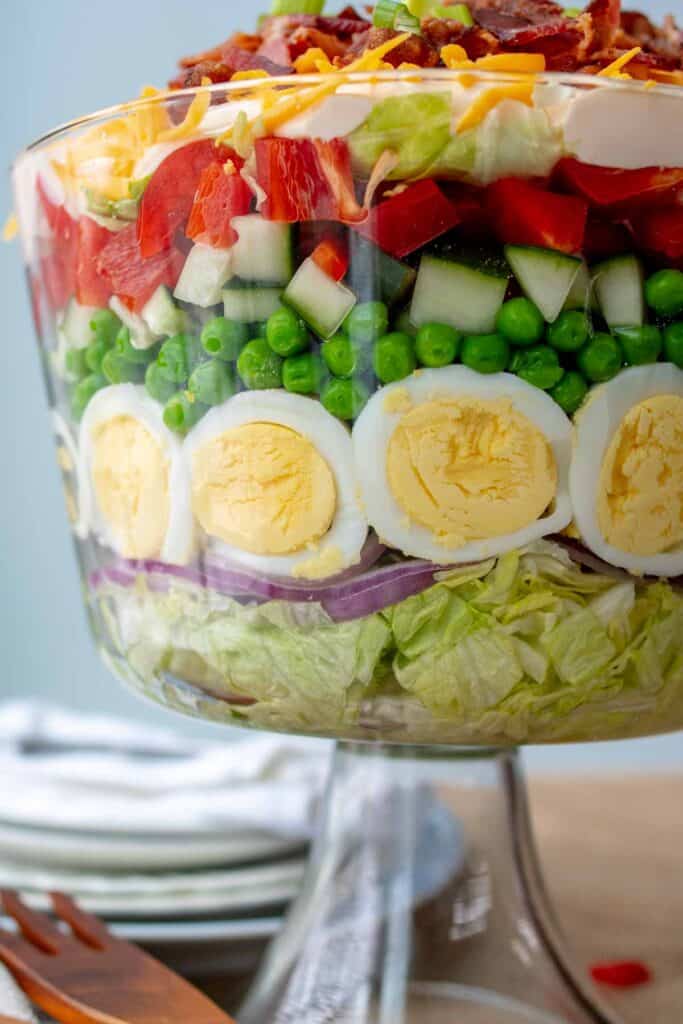 Side view of a trifle glass bowl with 7-Layer salad.