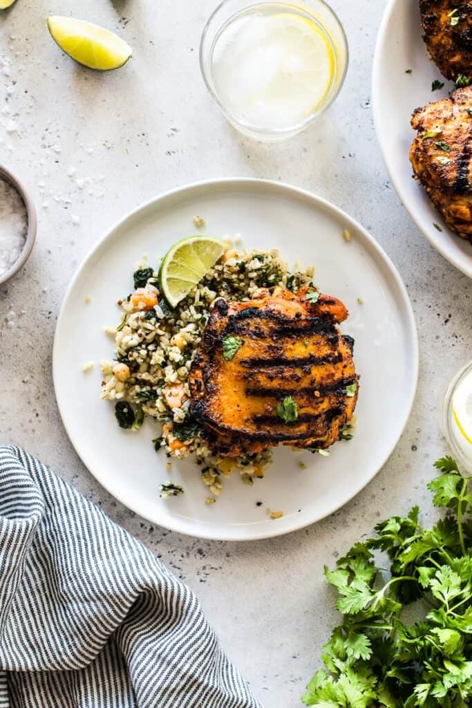 plate of pollo asado with a side of mexican quinoa salad with lime and cilantro on the table 