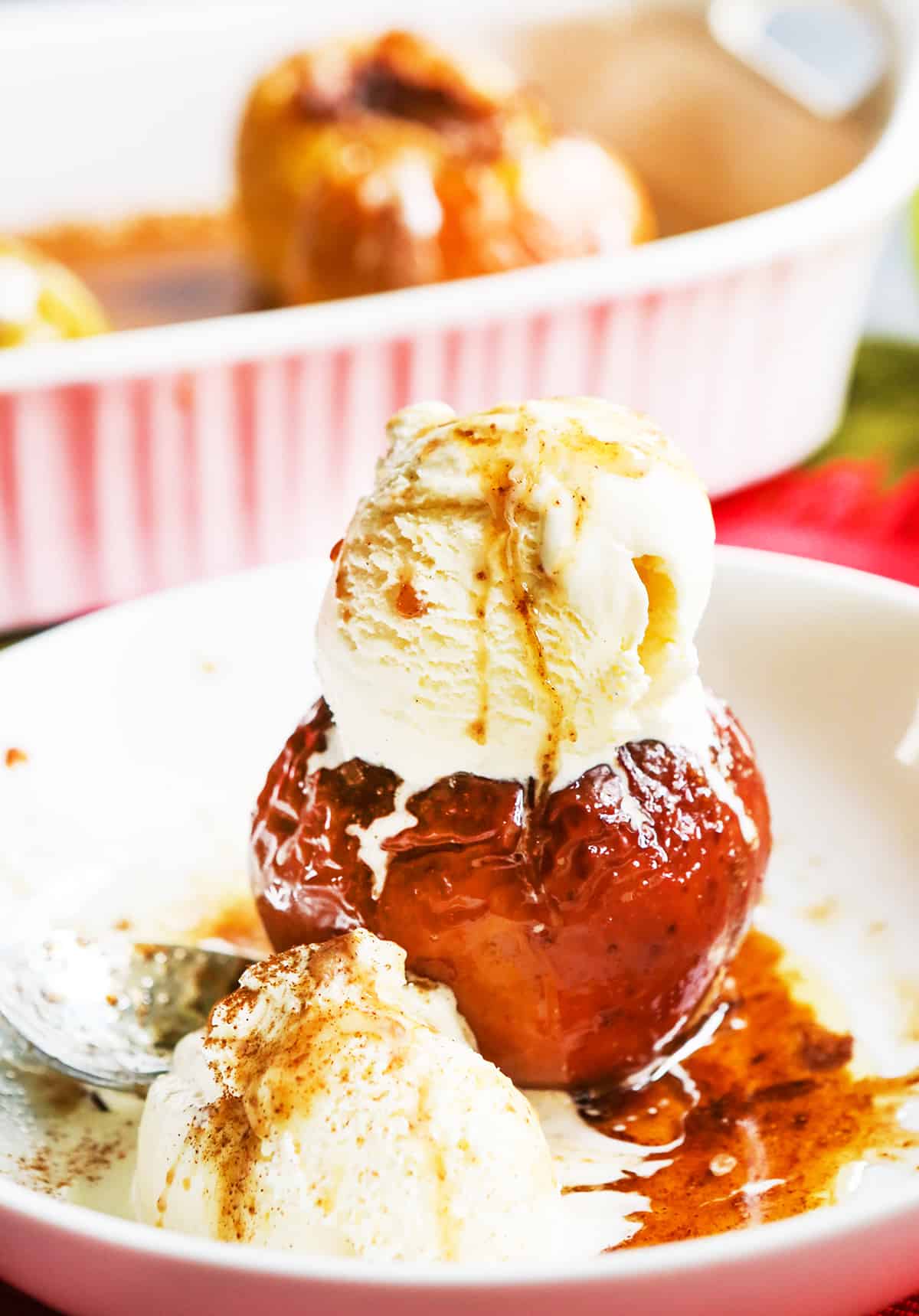 A baked apple served in a bowl with ice cream.