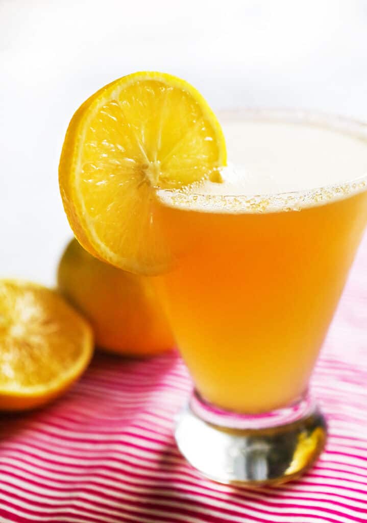 highball glass of lemon drop and an orange garnish slice