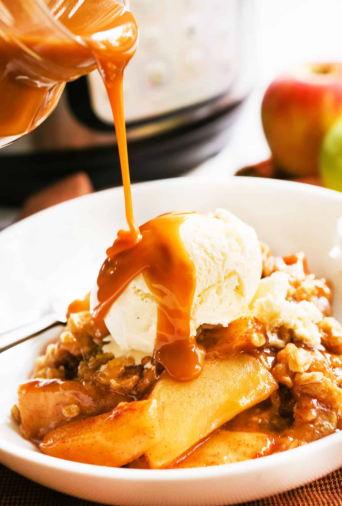 caramel being drizzled over helping of Instant Pot apple crisp,