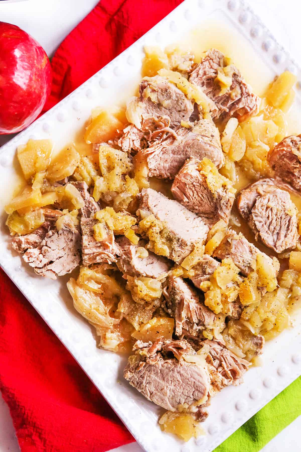 Looking down on on a platter with shredded pork and apples.