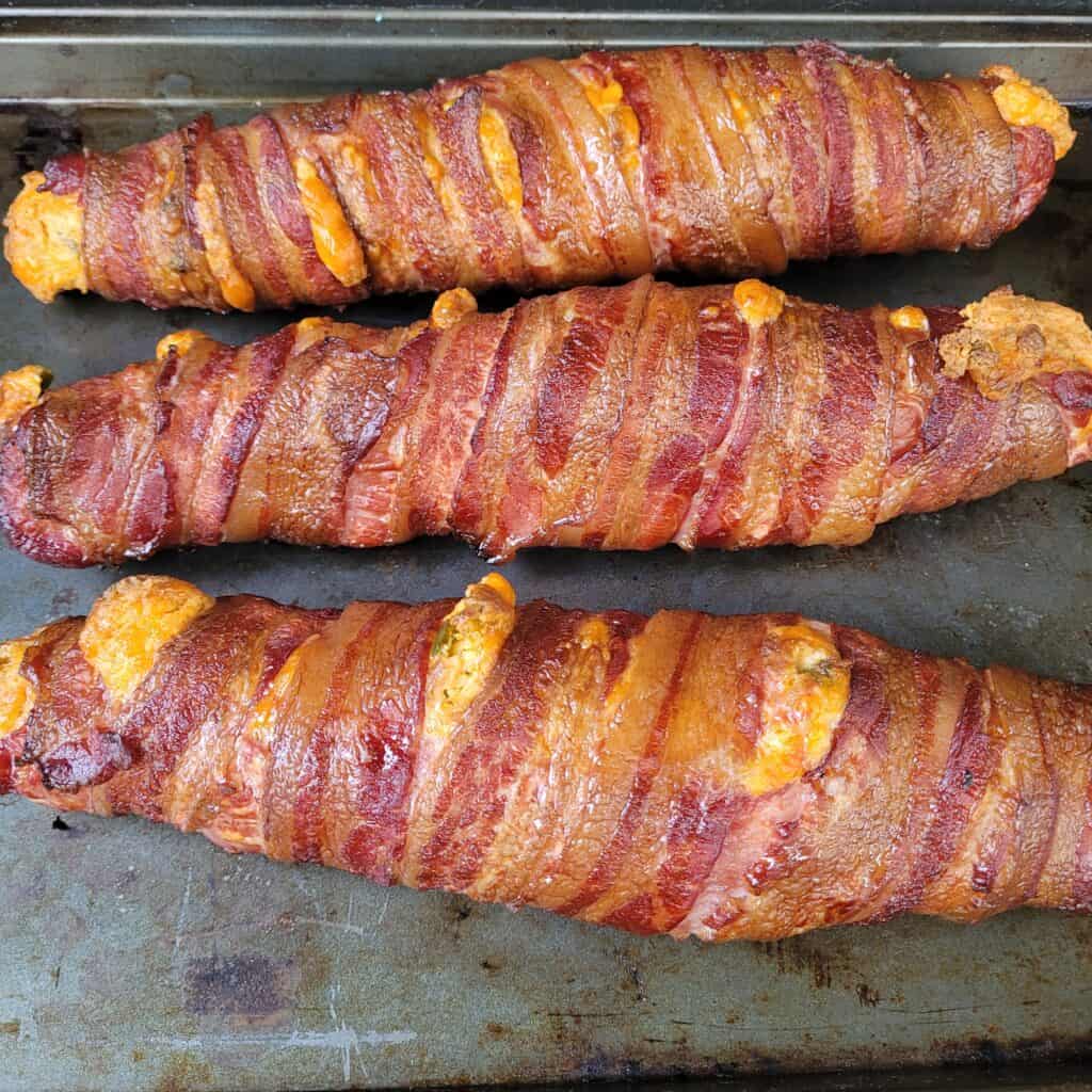 Baked jalapeno cheddar stuffed tenderloin sitting on a baking sheet. 