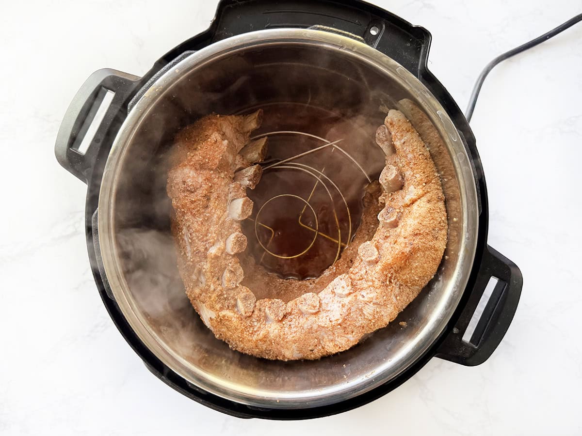 Delicious cooked ribs steaming inside an Instant Pot after the cover has been removed.