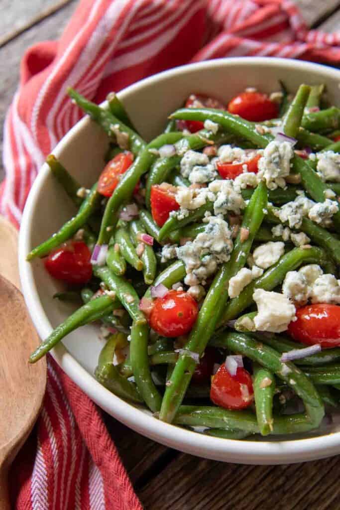 Bowl of marinated green bean salad on a table. 