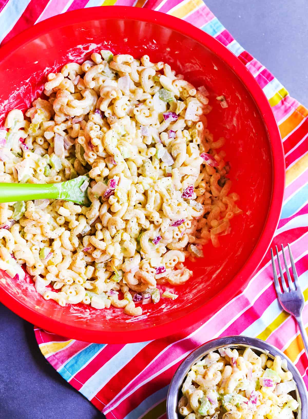 Red mixing bowl filled with macaroni salad.