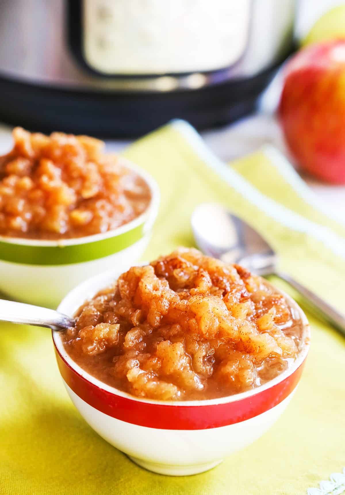 spoon inserted into a small bowl of instant pot applesauce.