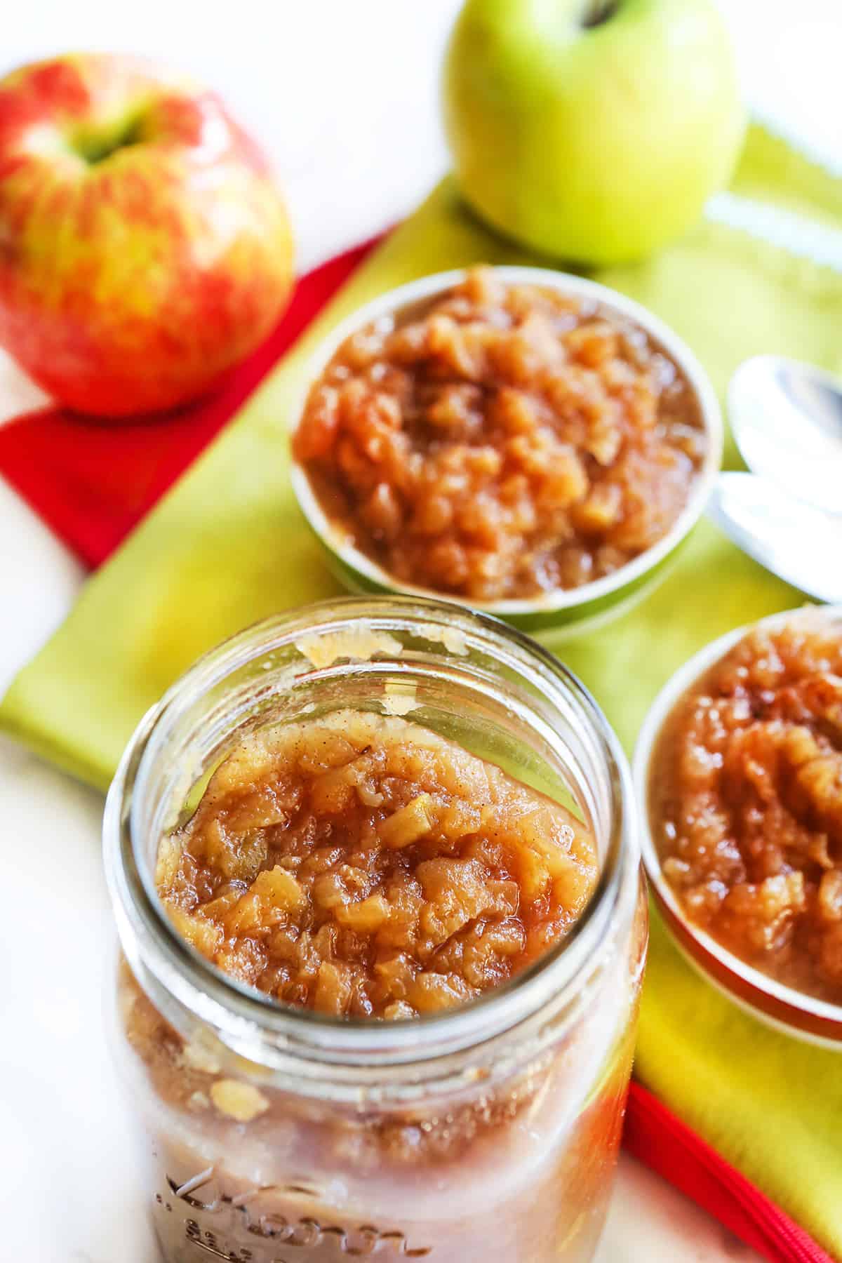 Mason jar of instant pot applesauce with a small bowl of applesauce next to it.