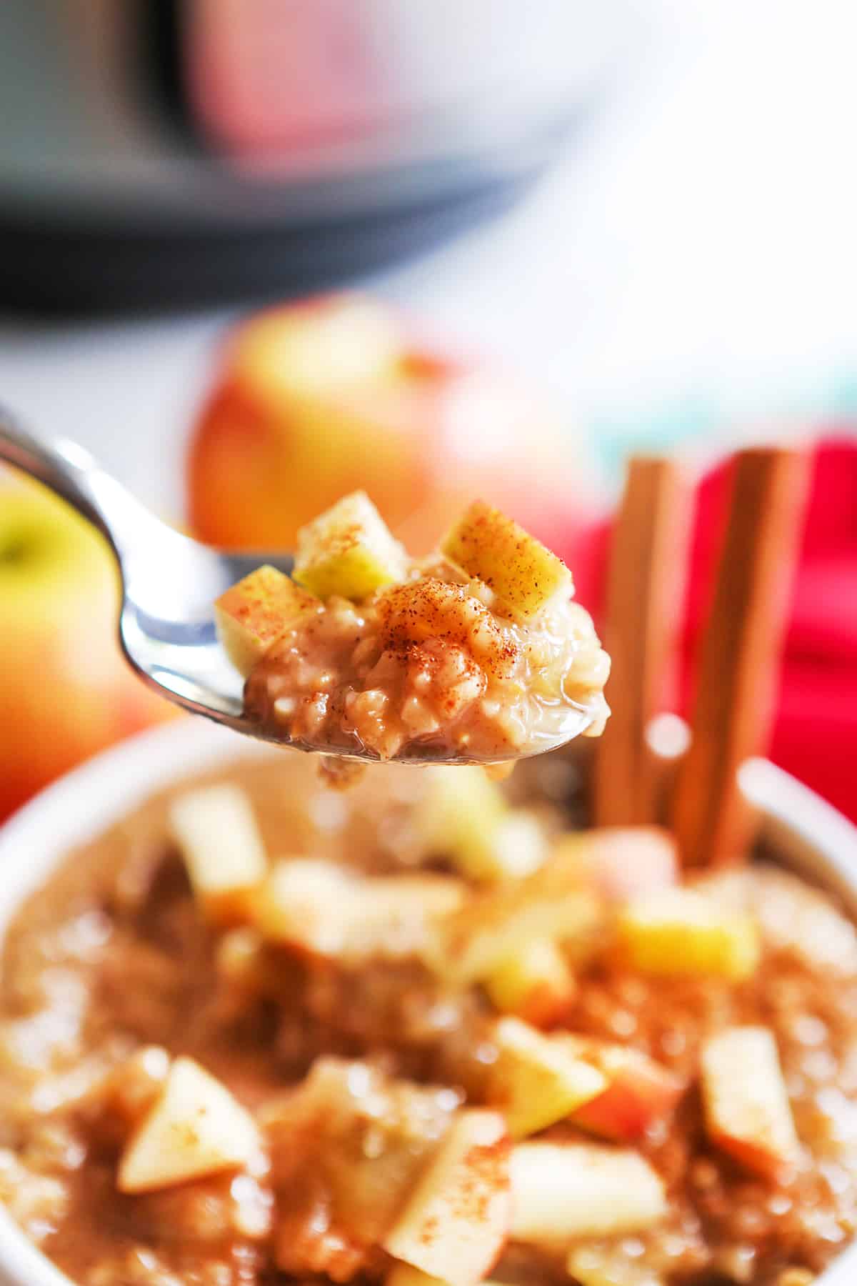 Spoon full of instant pot apple oatmeal in front of the bowl.