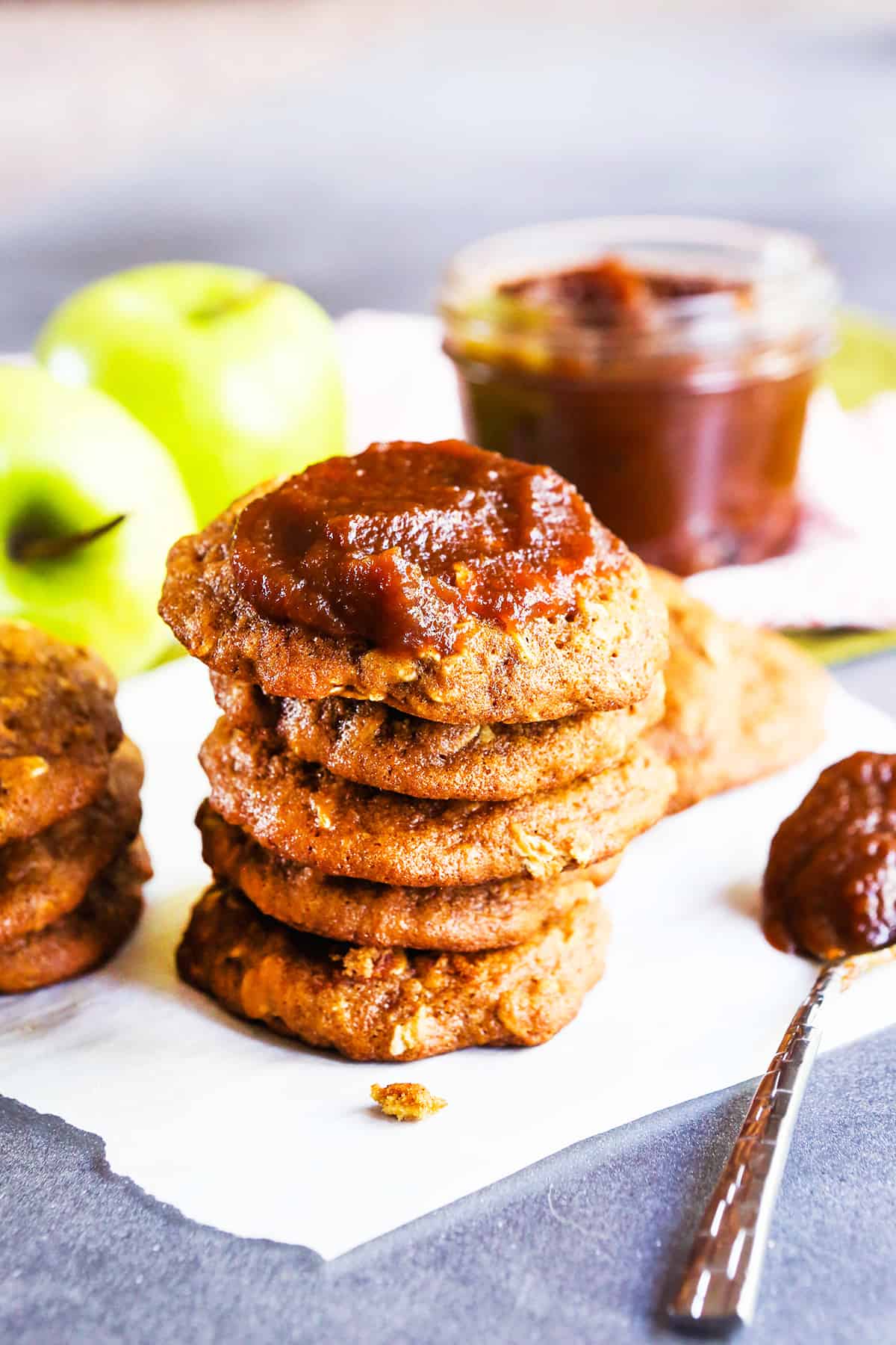 stack of apple butter oatmeal cookies with apple butter smeared on top.