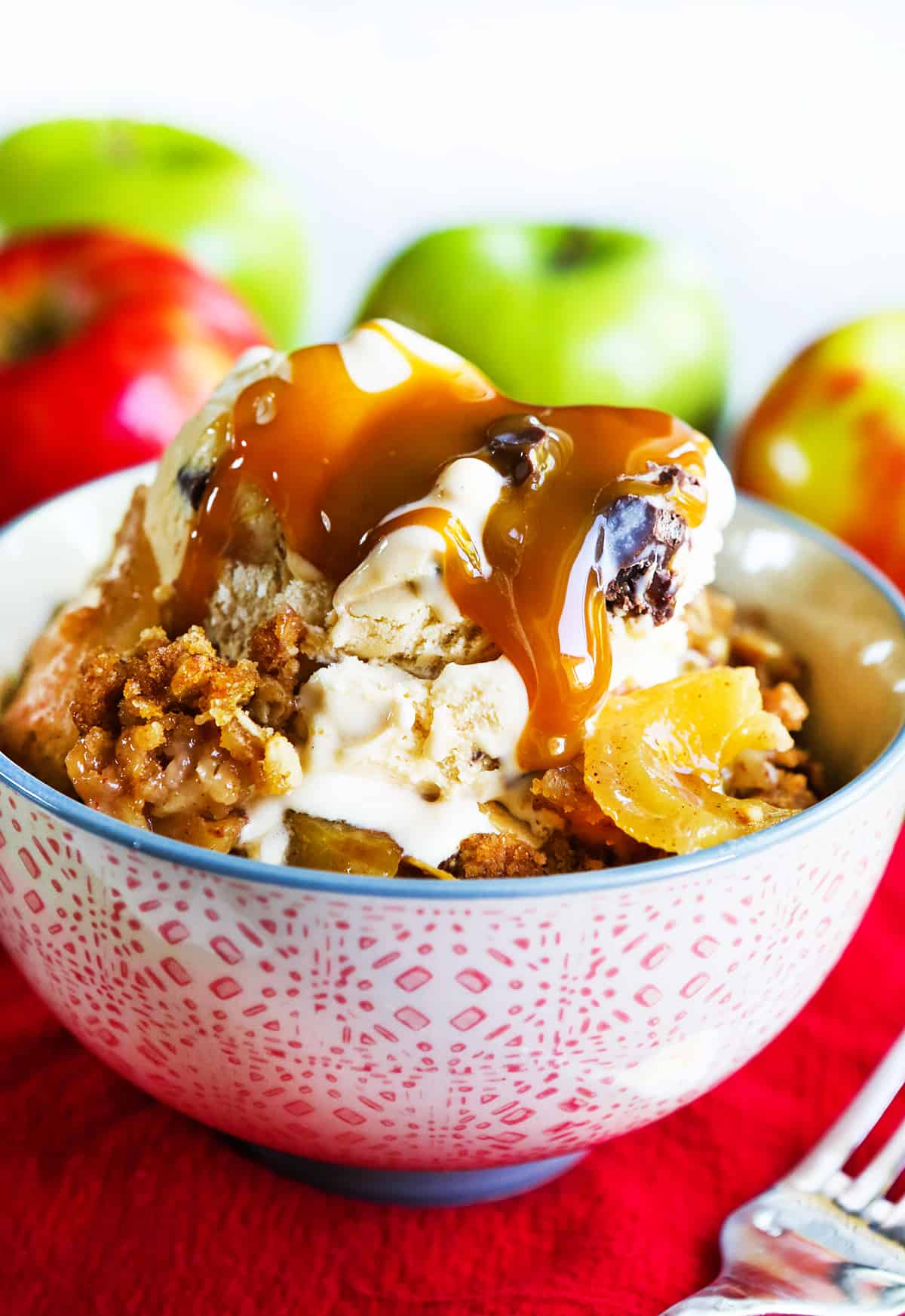 caramel oozing down a serving of classic apple crisp and vanilla ice cream.