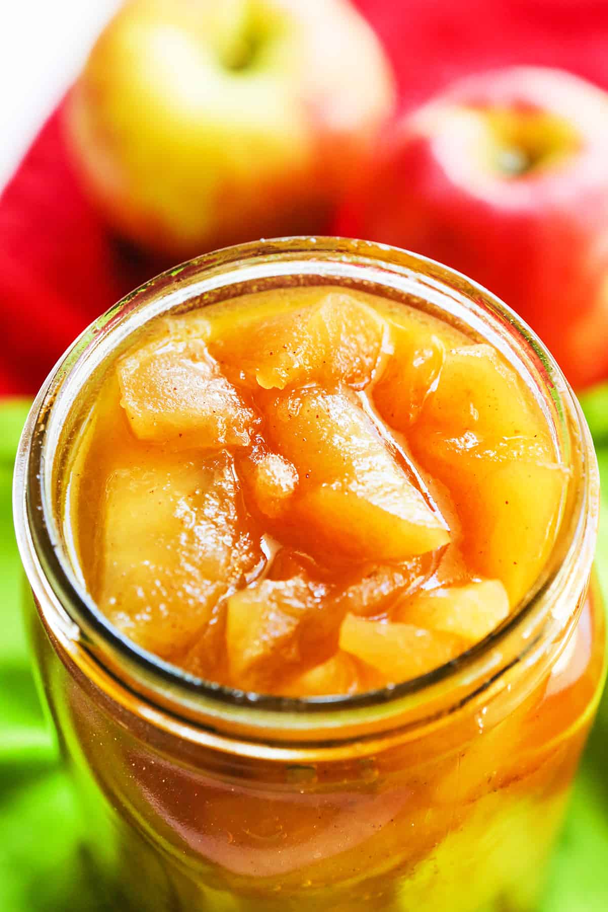 close up of apple pie filling in a mason jar with apples in background.