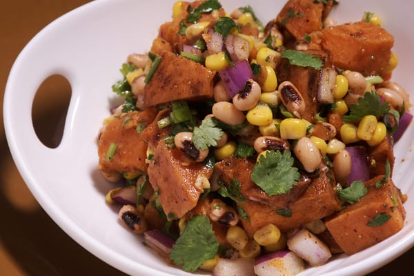 Sweet potato salad in a serving bowl with cilantro sprinkled on top. 