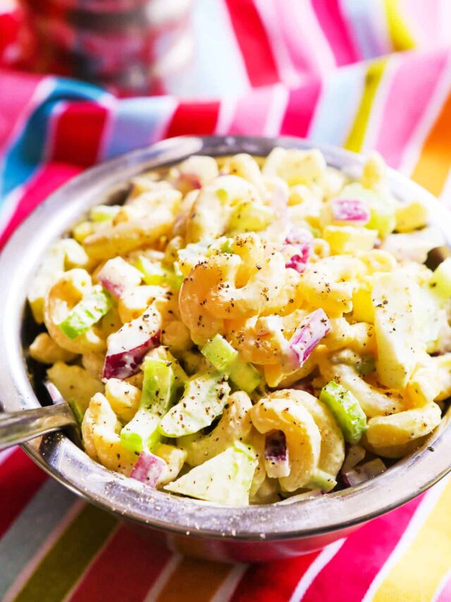 Deli macaroni salad in a bowl with a spoon. 