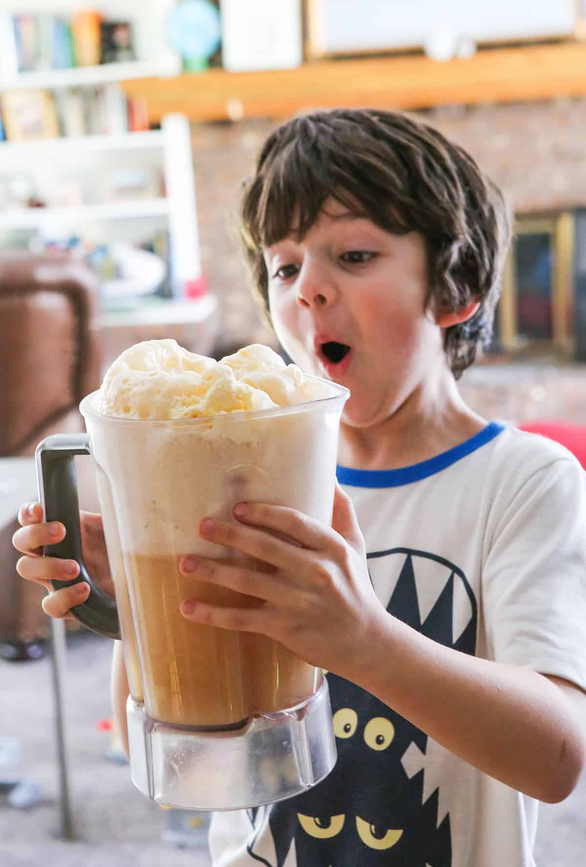 Cute boy in awe and holding a pitcher filled with butterbeer.
