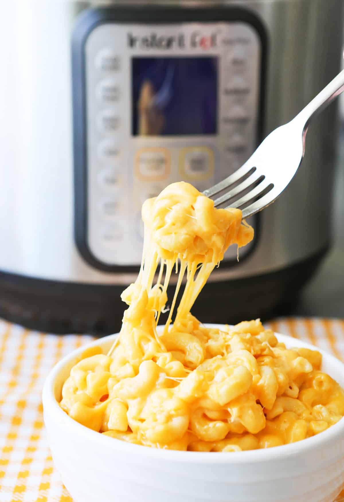 Fork pulling mac and cheese out of bowl.