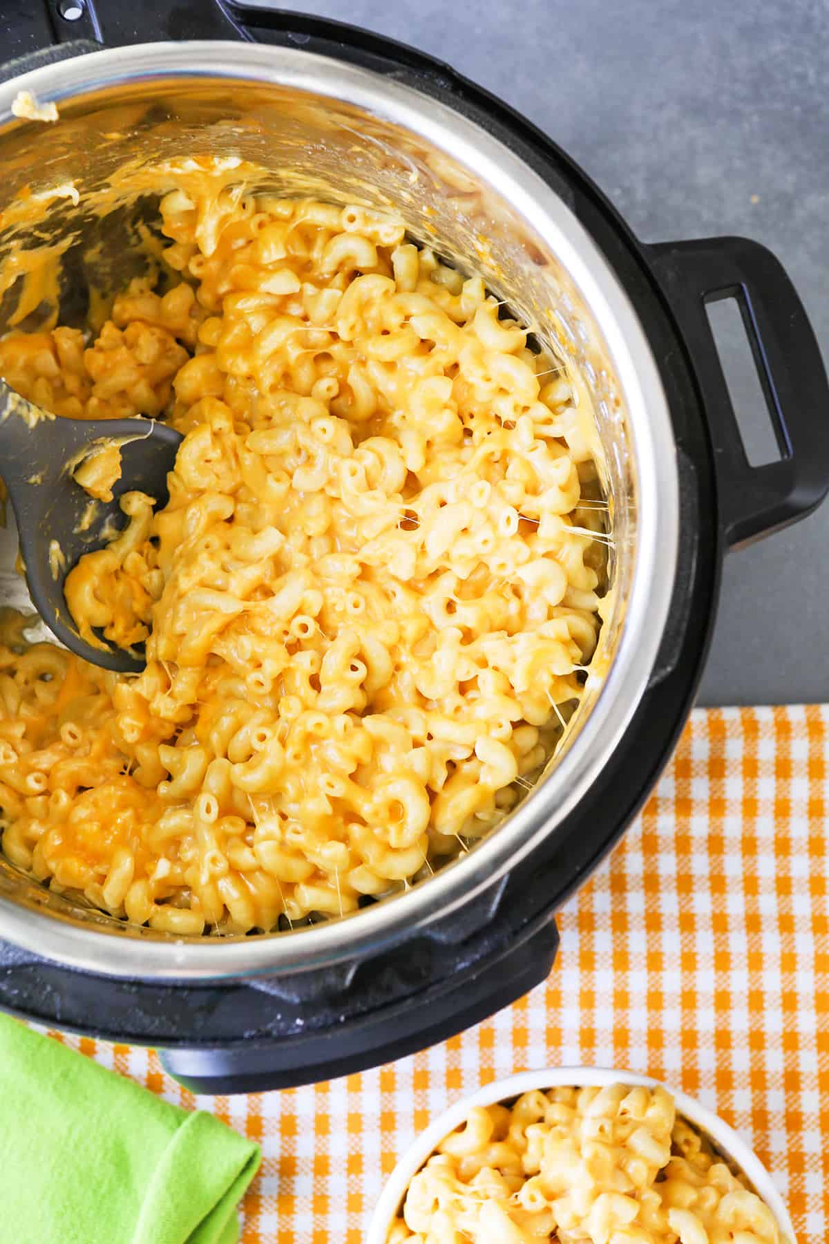 Instant Pot full of mac and cheese with bowl next to it.