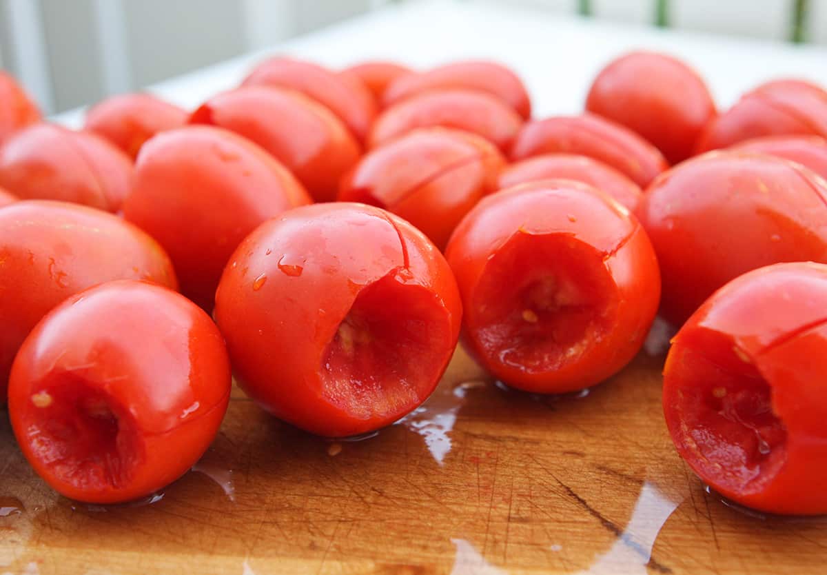 Roma tomatoes on a cutting board, prepped for freezing.