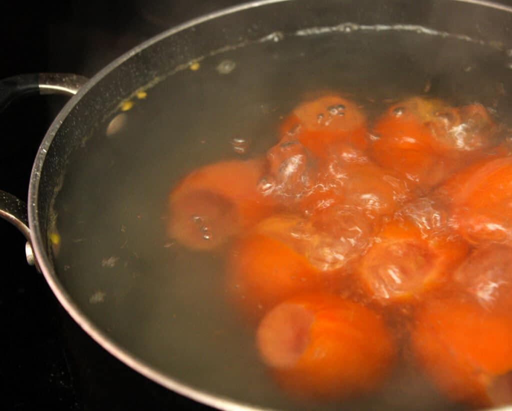Tomatoes in a saucepan of boiling water.