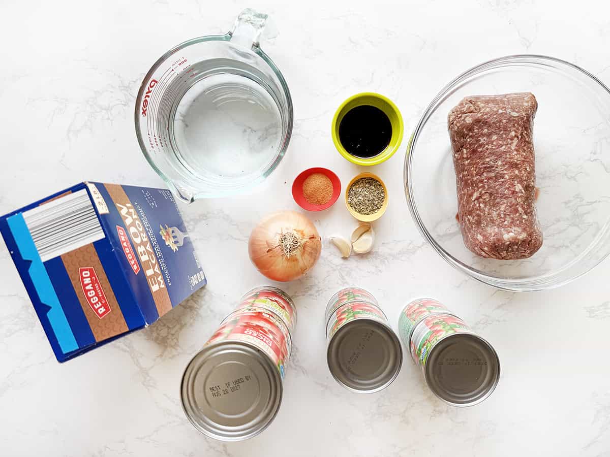Ingredients for goulash sitting on a white counter.