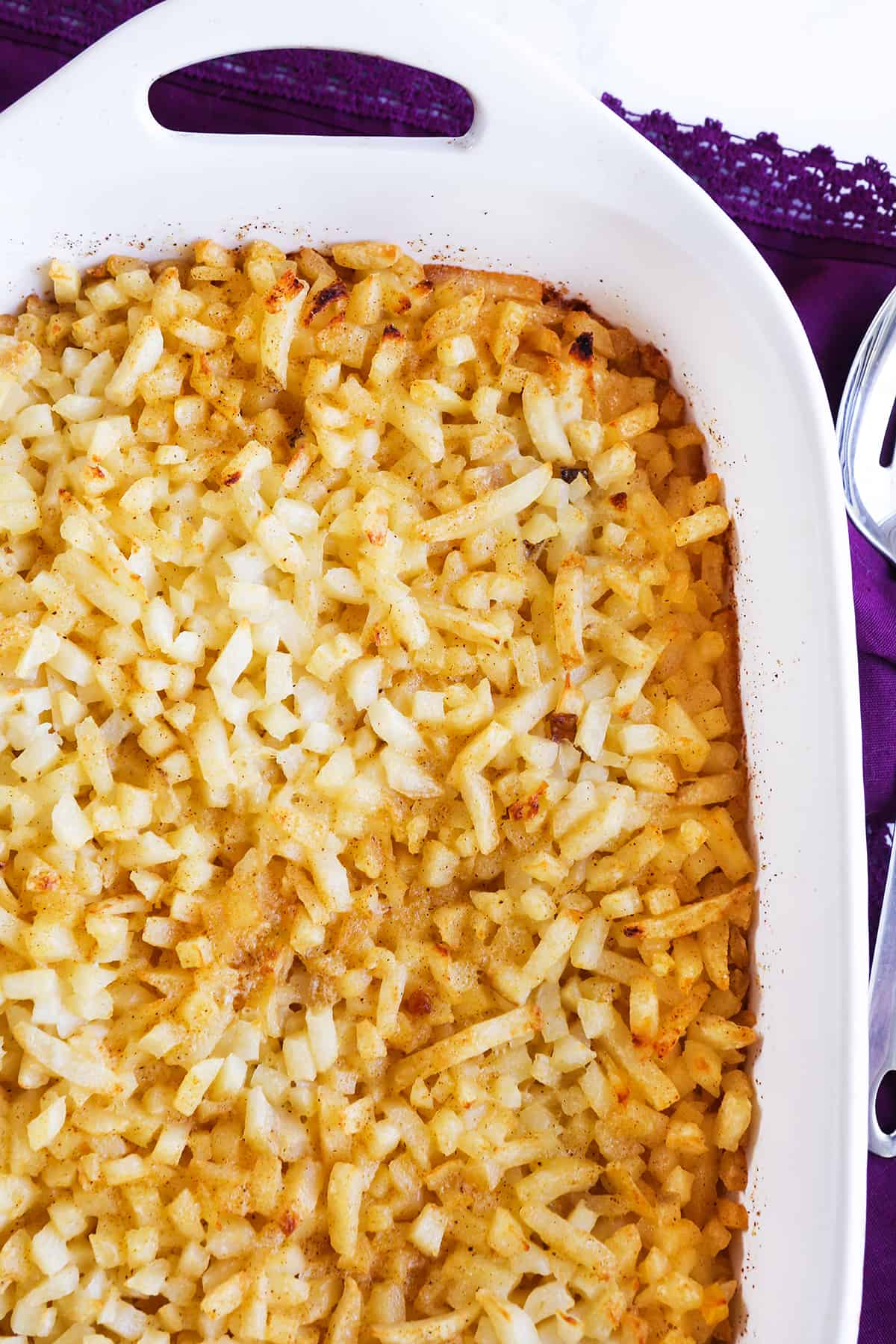 Top view of a hash brown casserole in a white baking dish.