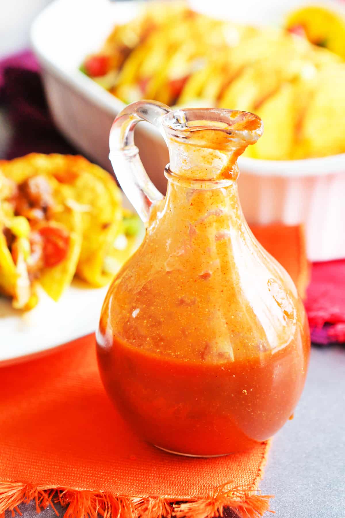 Jar of taco sauce sitting next to hard shell tacos.