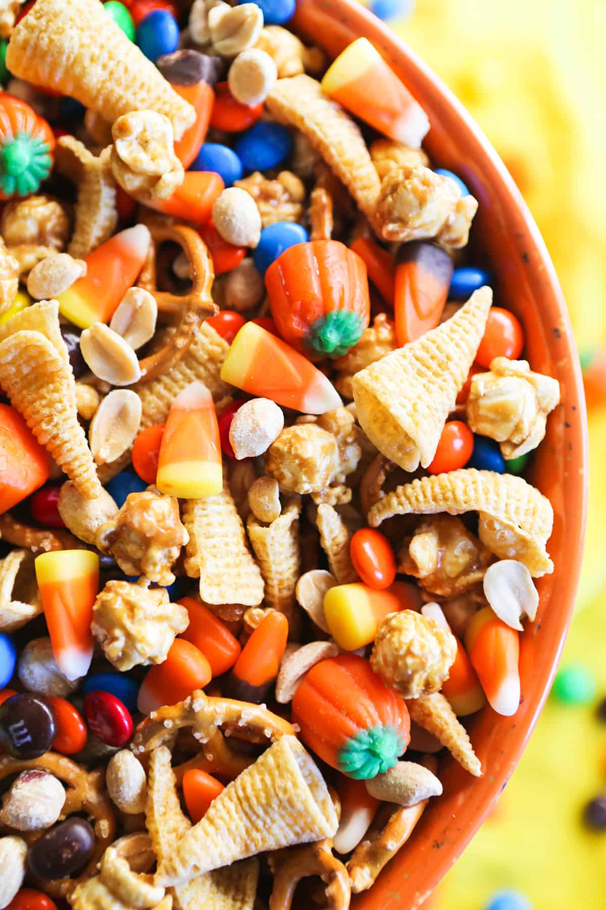 close of halloween snack mix in orange mixing bowl.