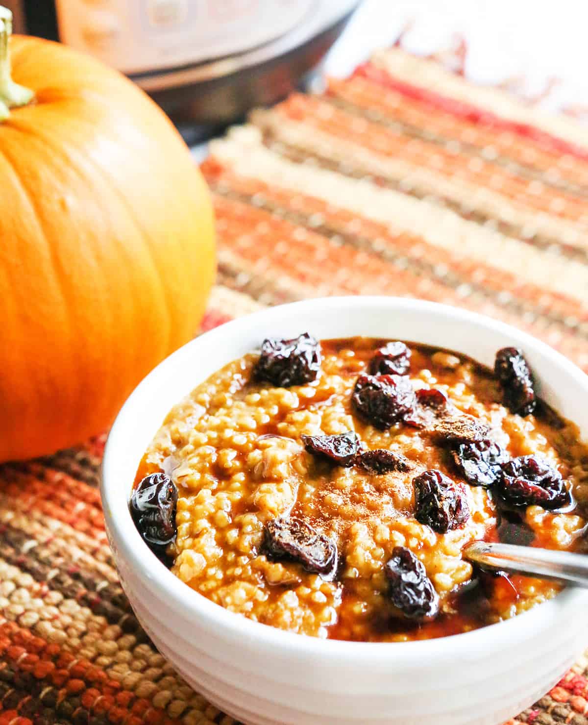 Bowl of Instant Pot pumpkin oatmeal with Instant Pot in background. 