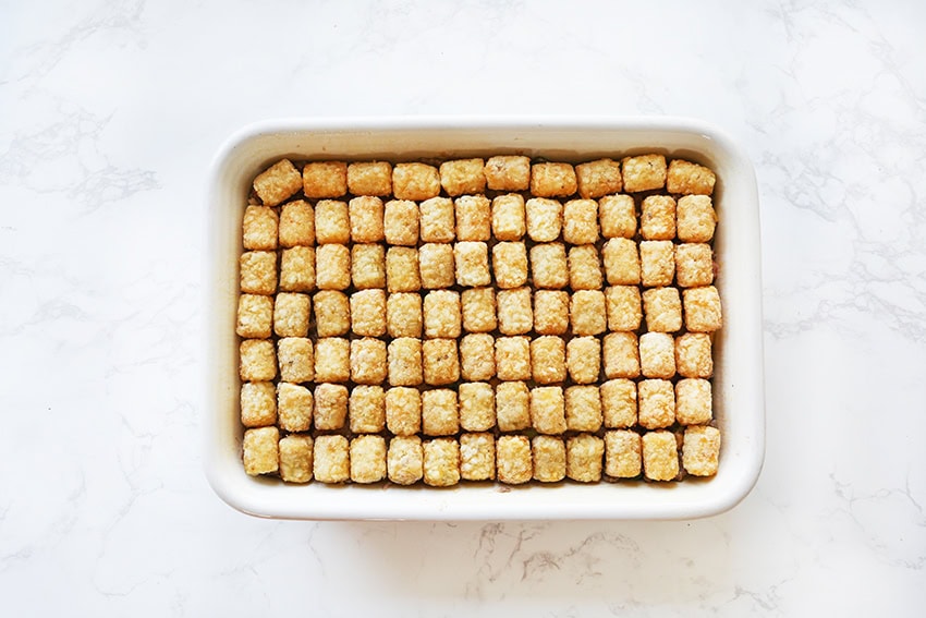 Sweetened breakfast cereal cubes in a white rectangular dish on a marble surface.