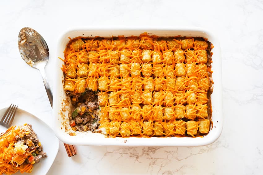 Cheesy beef and pasta casserole in a white baking dish, ready to serve.
