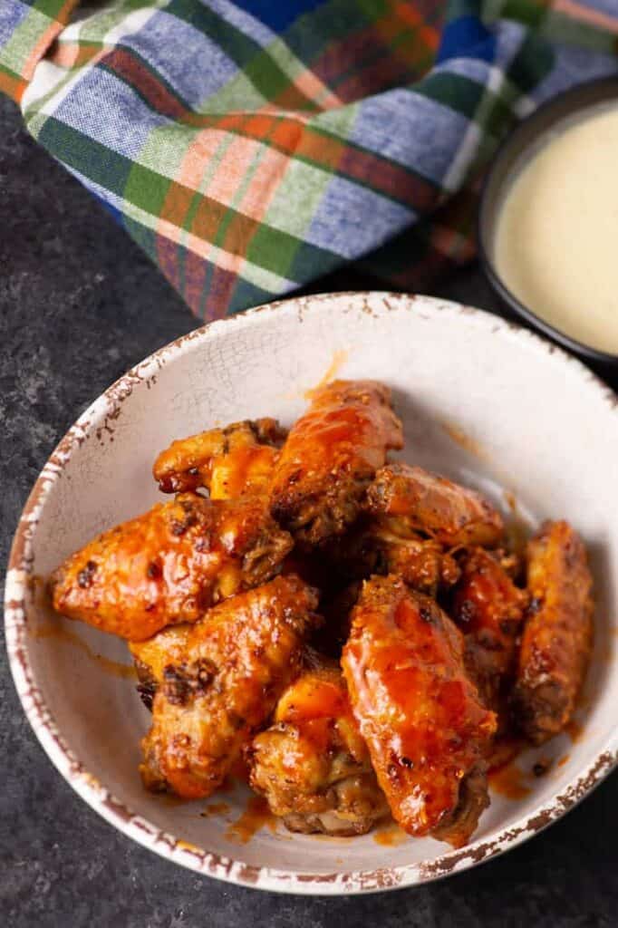 Bowl of baked buffalo wings.