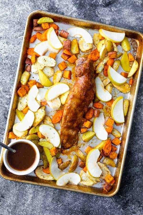 Sheet pan with pork tenderloin, baked apples and root vegetables.