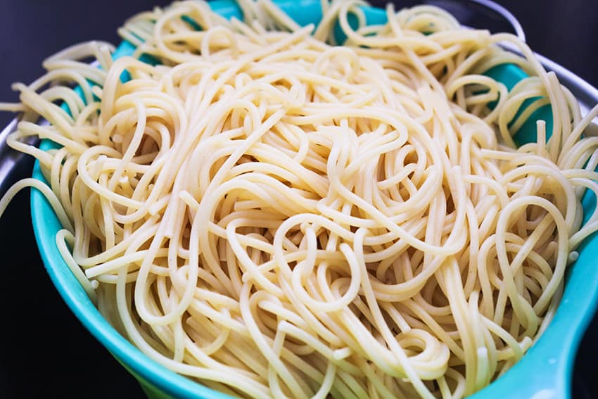 Collander filled with cooked spaghetti.