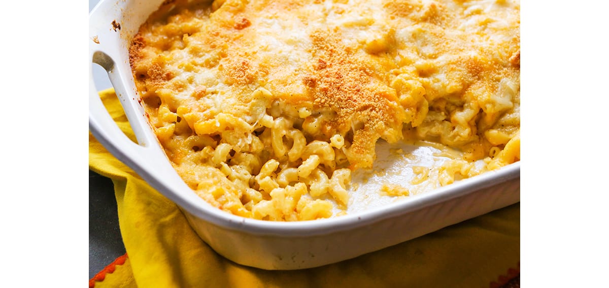 Mac and cheese in a baking dish with a scoop removed.