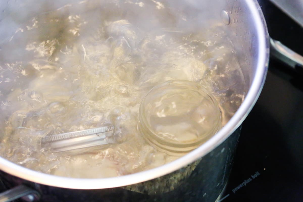 Large pot of boiling water with mason jars inside.