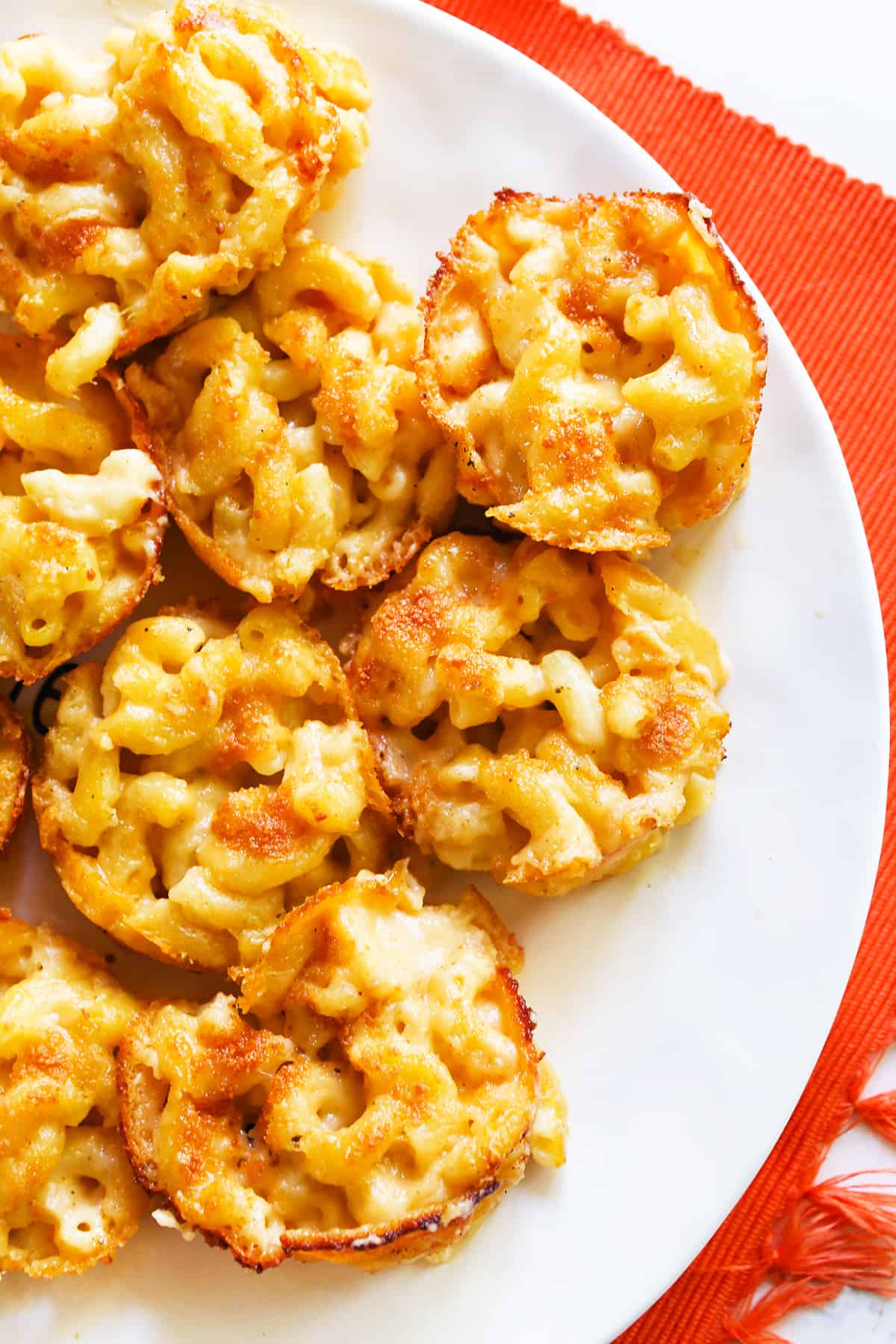 Top view of a serving plate filled with mac and cheese bites.