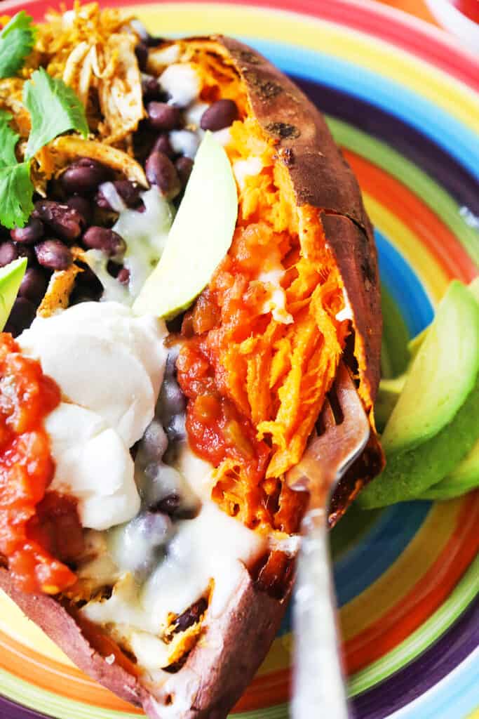 Baked stuffed sweet potatoes sitting on a plate. 