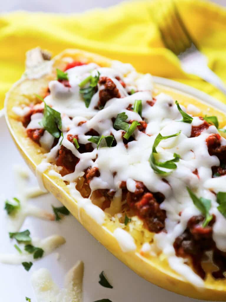 Stuffeed spaghetti squash with ground beef and cheese on a plate. 