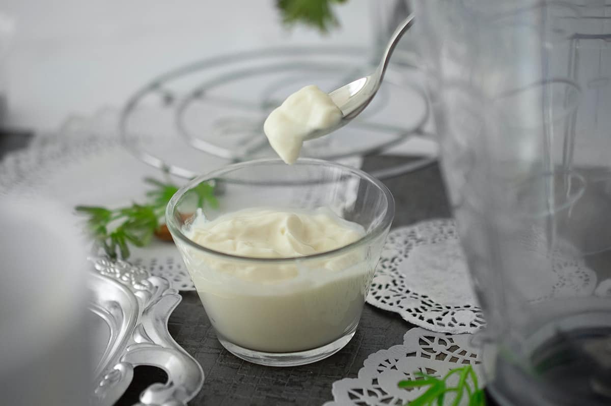 Yogurt in a glass dish, with a spoonful being removed.
