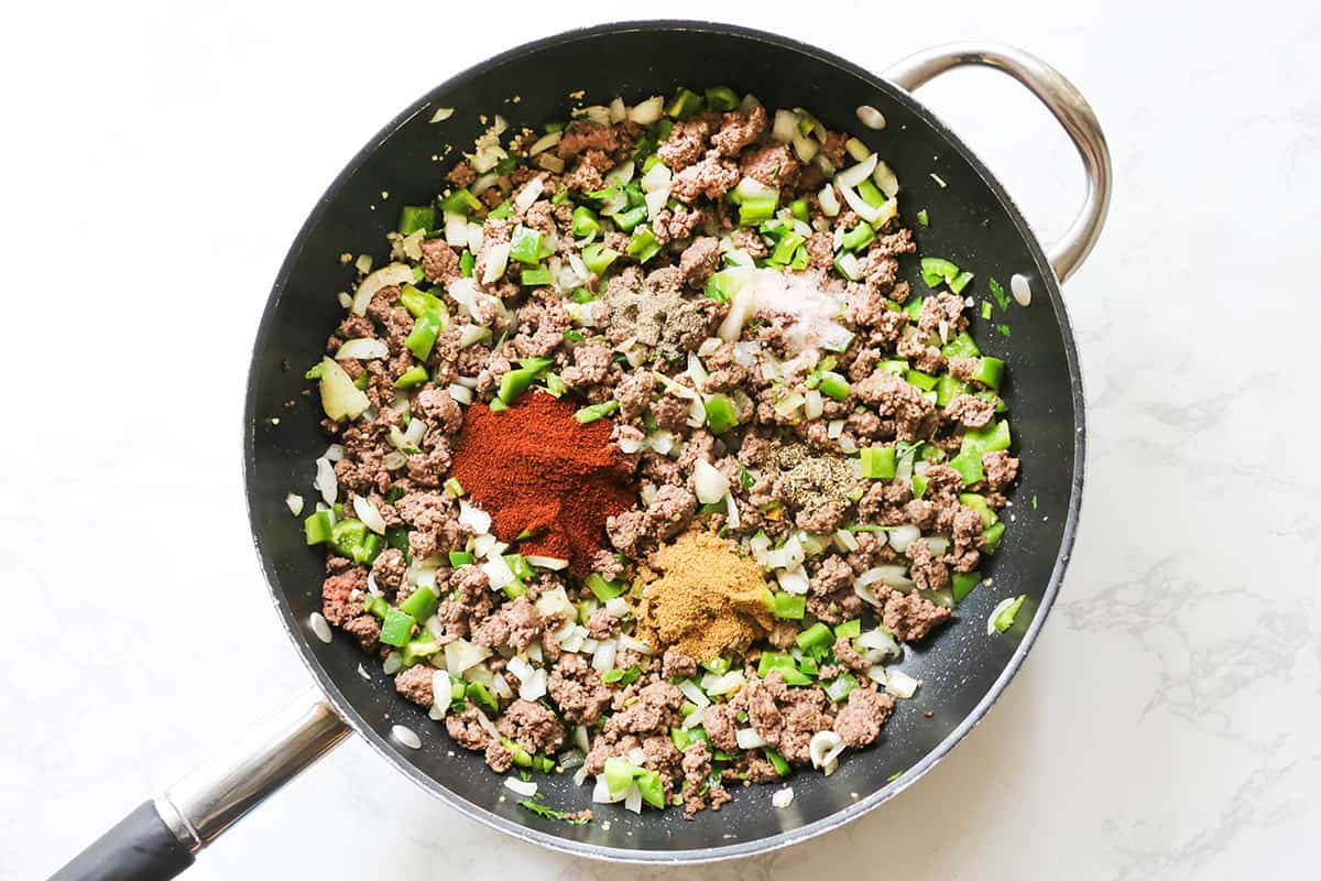 Cooked ground meat in a skillet with spices and seasonings.