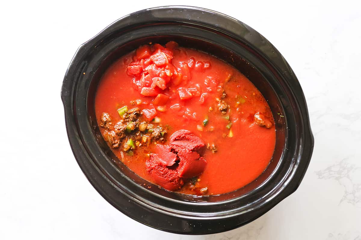 Tomato paste and sauces in a slow cooker along with other chili ingredients.