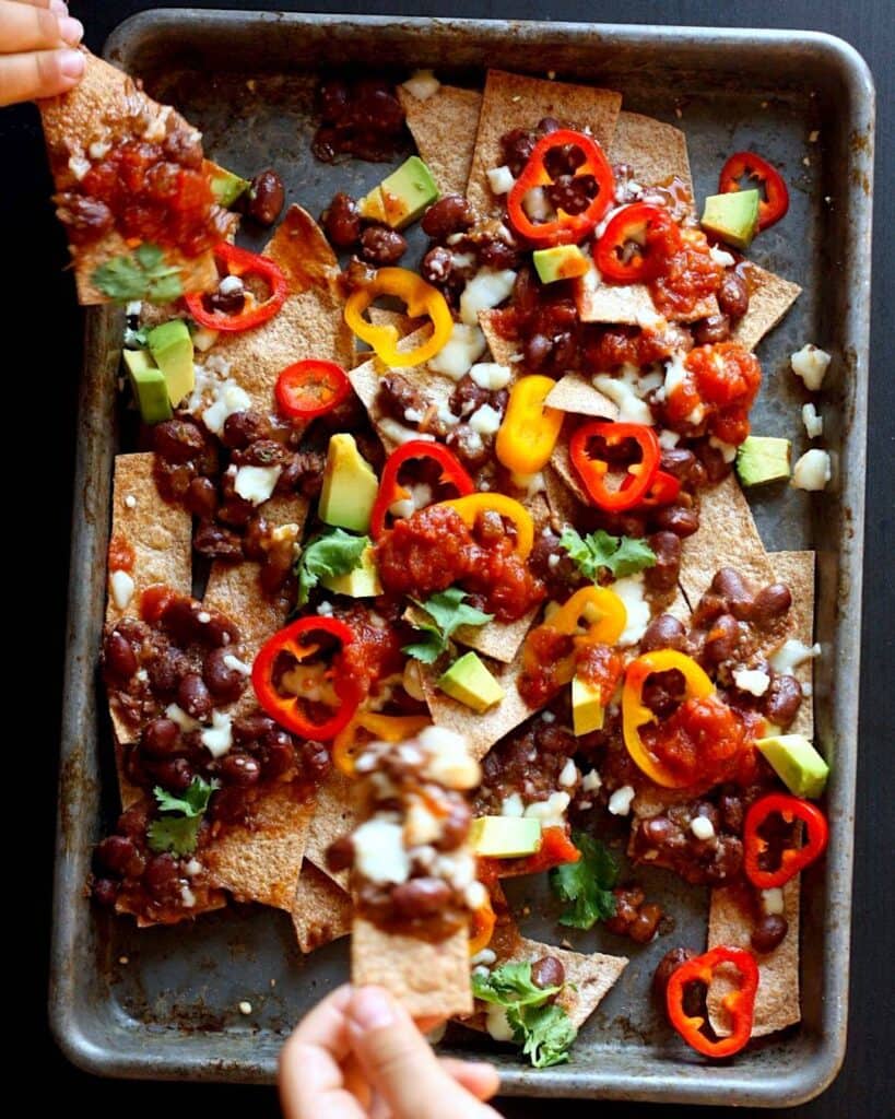 Sheet pan filled with chili topped nachos. 