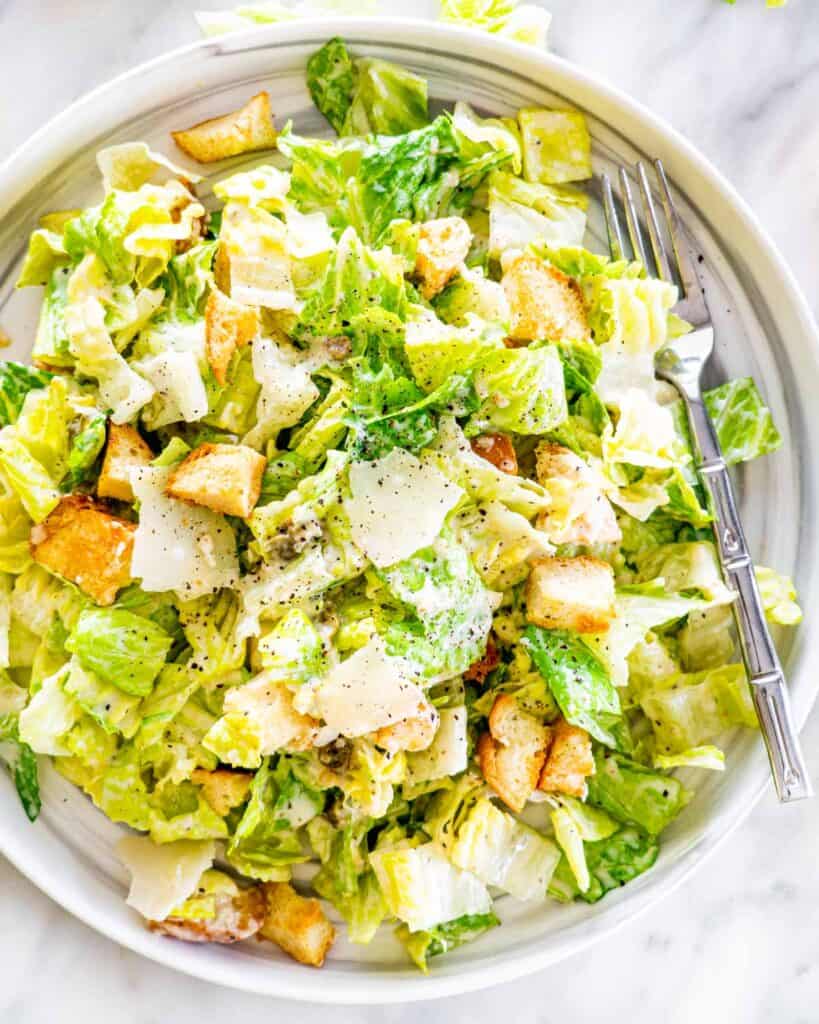 Large salad bowl with caesar salad and shaved parmesan cheese. 