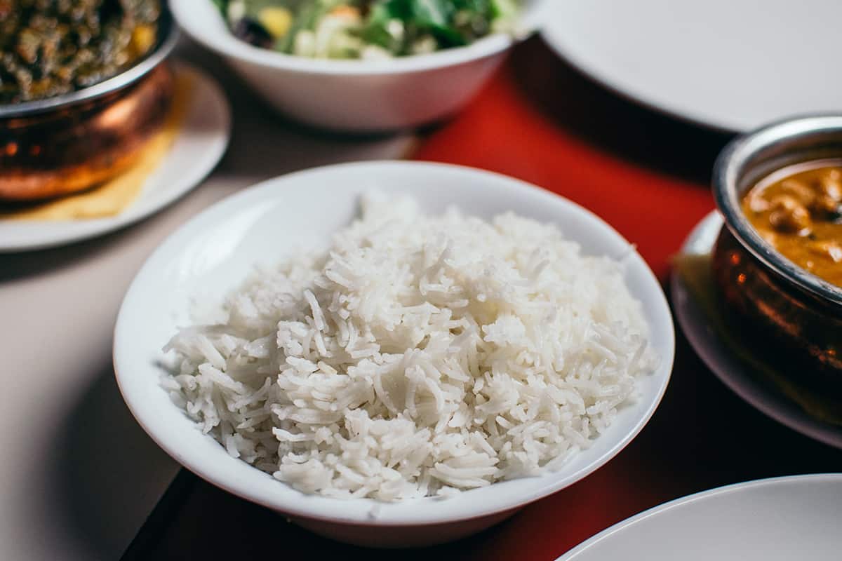 Bowl filled with cooked white rice on a table.