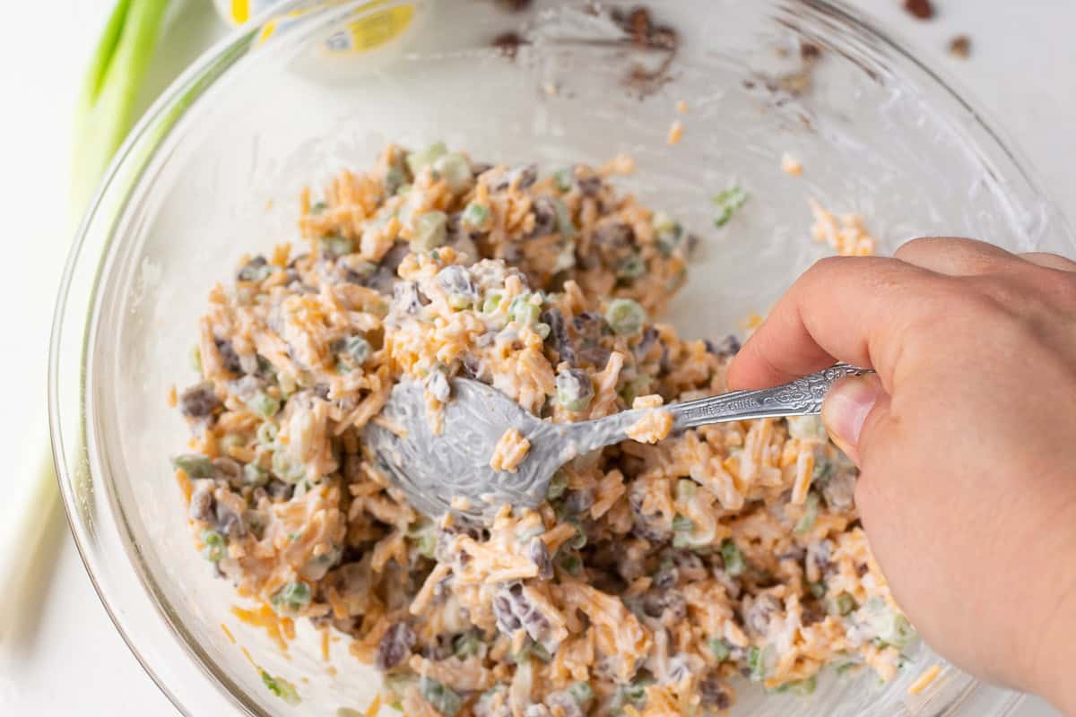 Creamy raspberry dip mixture with chopped ingredients in a glass bowl.