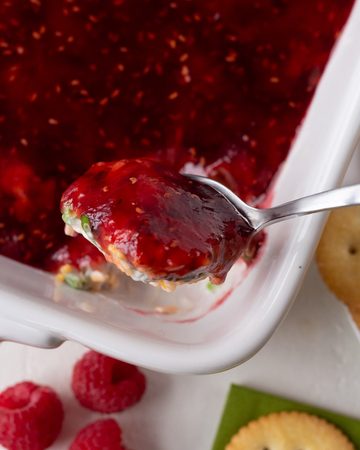 Close-up of raspberry dip with a spoonful of dip and fresh raspberries.