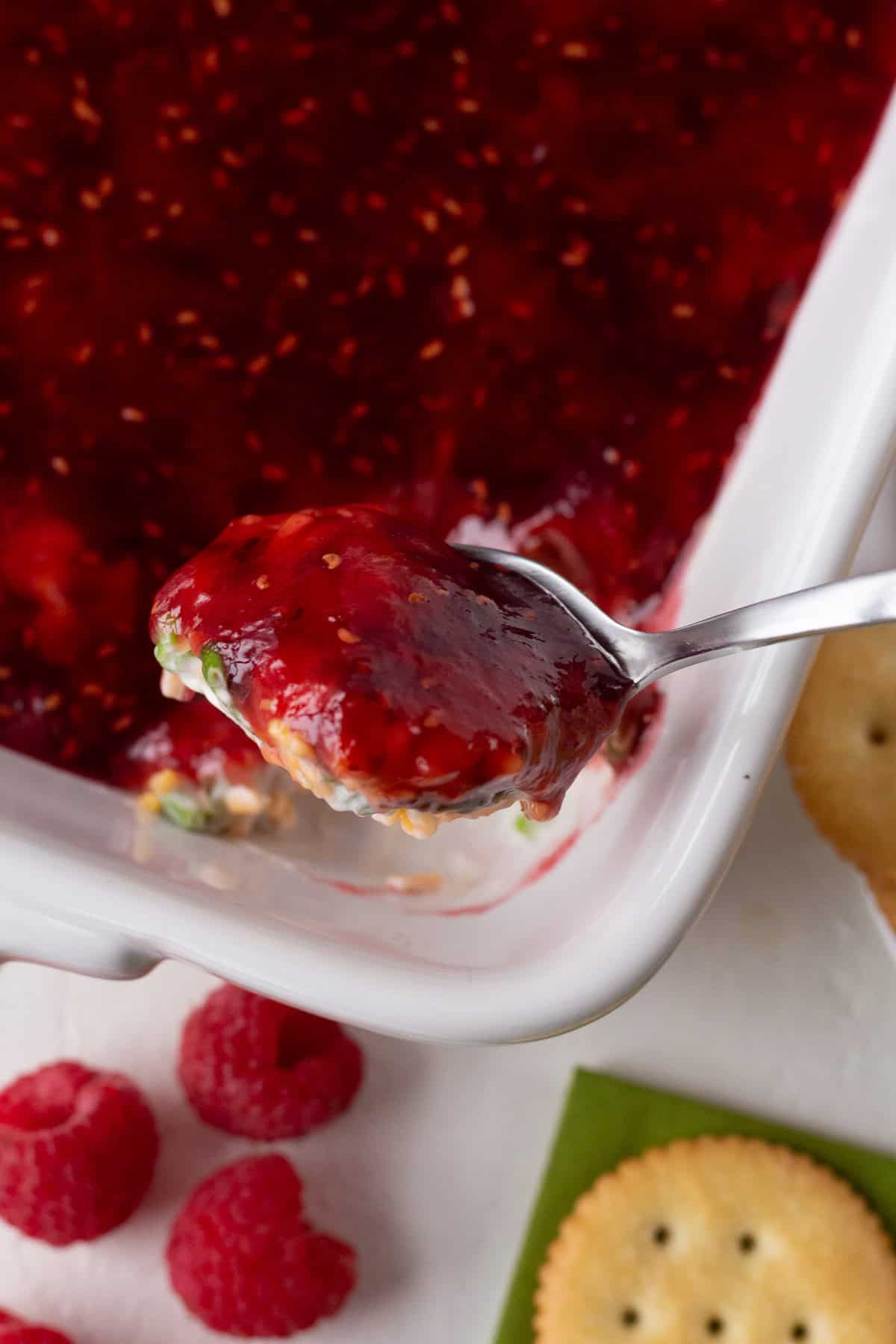 Close-up of raspberry dip with a spoonful of dip and fresh raspberries.