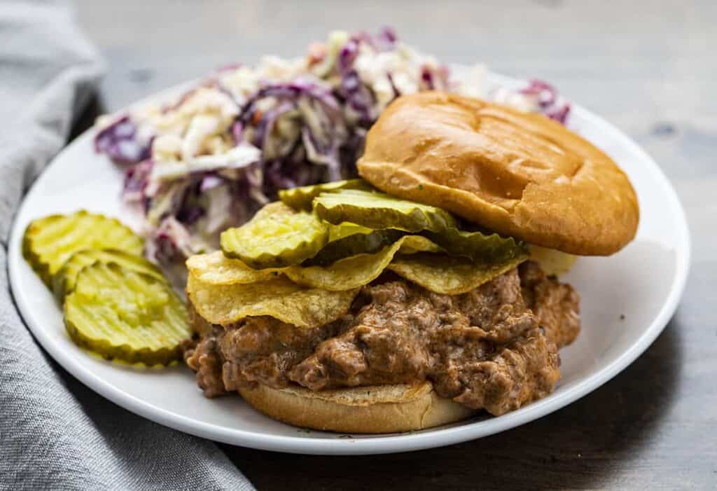 Minnesota sloppy joe with coleslaw and pickles on the plate.