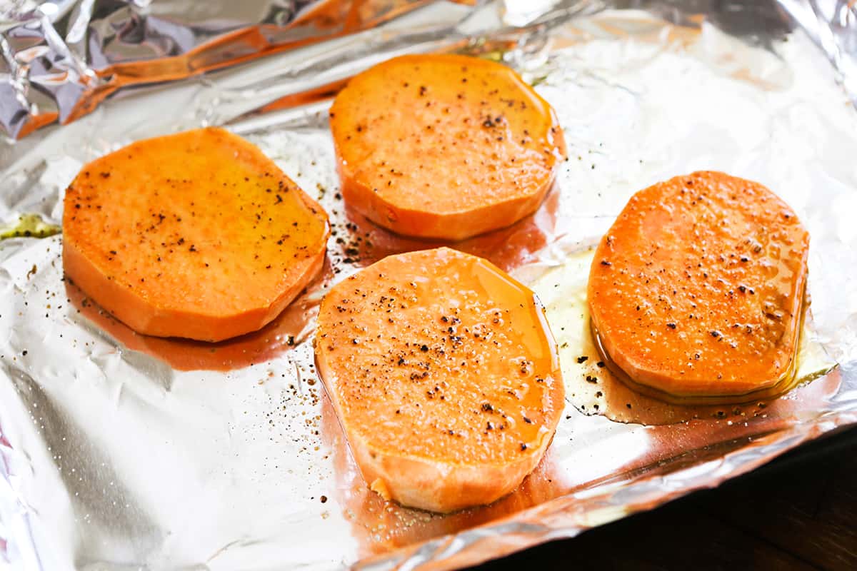 Sliced sweet potatoes on a baking sheet.
