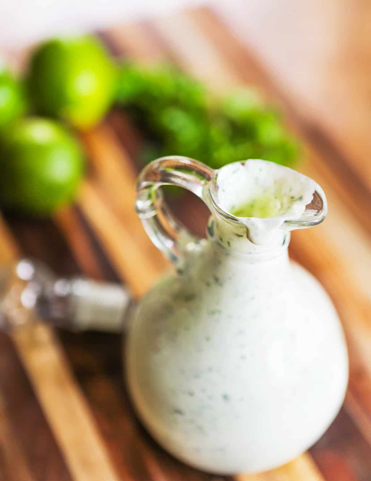 Container filled with cilantro lime sauce, dripping down the sides.